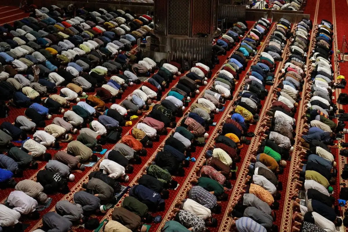 A large congregation standing in prayer inside a mosque during Ramadan nights